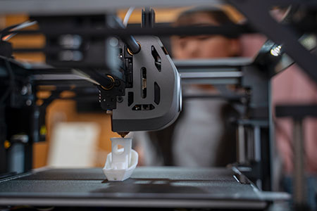 熔融沉积建模 FDM 3D 打印机挤出热塑性长丝，逐层构建小型聚合物部件。