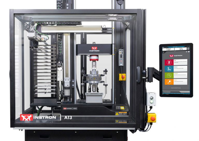 Instron 68TM table model integrated into an AT3 automated testing system with a specimen rack and automated loading actuator, enclosed for unattended automated testing.
