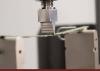 Instron three-point bend fixture applying a load to a printed circuit board specimen during PCB bend testing